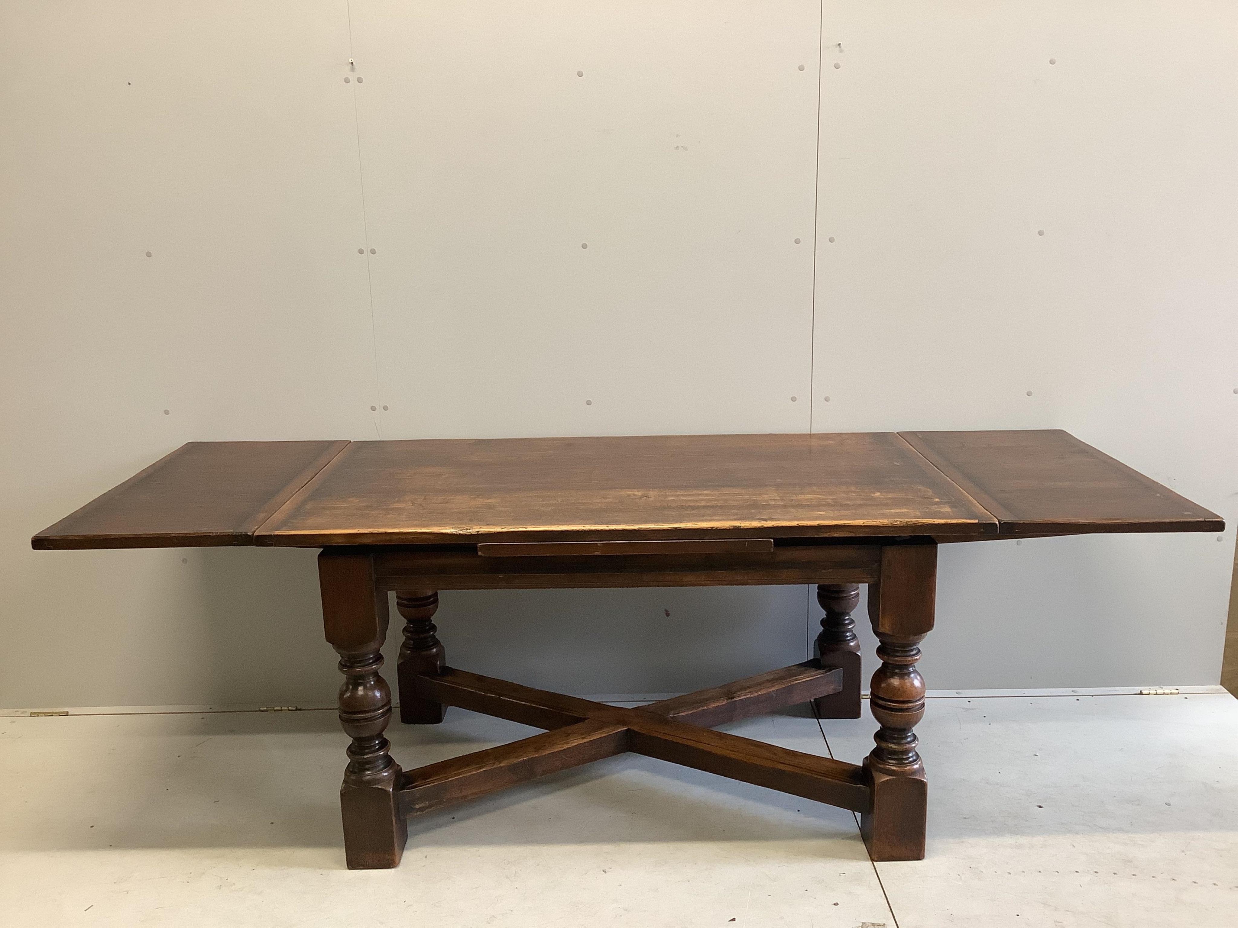 An 18th century style rectangular oak draw leaf refectory dining table, width 244cm extended, depth 85cm, height 79cm together with seven caned oak dining chairs, two with arms. Condition - fair to good